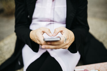 Schwangere Frau benutzt Mobiltelefon - JRFF01004