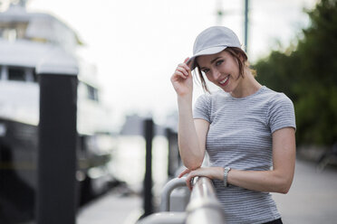 Portrait of smiling woman wearing basecap - GIOF01601