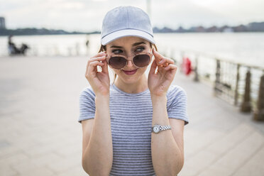 Porträt einer Frau mit Sonnenbrille, die etwas beobachtet - GIOF01608