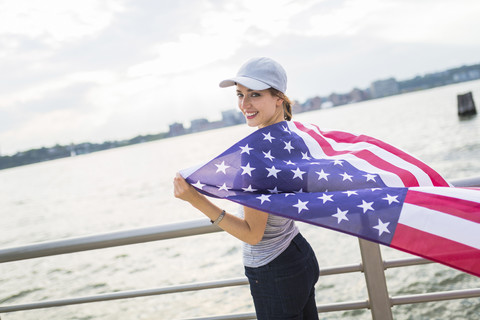 USA, Manhattan, glückliche Frau mit amerikanischer Flagge, lizenzfreies Stockfoto