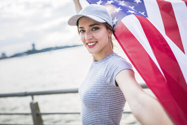 Porträt einer lächelnden Frau mit amerikanischer Flagge - GIOF01613