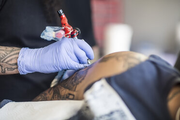 Tattoo artist tattooing an arm - ZEF11585