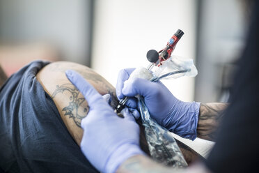 Tattoo artist tattooing an arm - ZEF11586