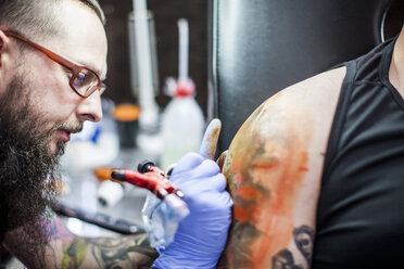 Tattoo artist tattooing an arm - ZEF11598
