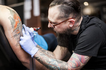 Tattoo artist tattooing an arm - ZEF11600