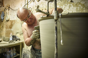 Töpfer in der Werkstatt bei der Arbeit an einer großen Terrakotta-Vase - DIKF00232