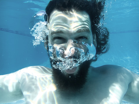 Mann taucht im Schwimmbad unter, lizenzfreies Stockfoto