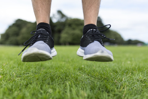 Schuhe eines Sportlers, der auf eine Wiese springt, lizenzfreies Stockfoto