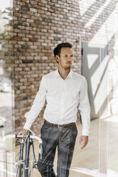 Businessman with bicycle in office - KNSF00452