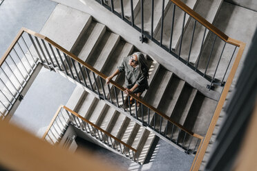 Woman with long grey hair in staircase - KNSF00454