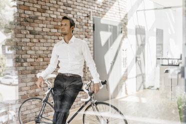 Geschäftsmann mit Fahrrad im Büro - KNSF00455