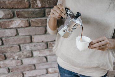 Woman pouring coffee into cup - KNSF00482