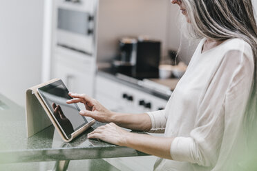 Frau in Küche mit Tablet - KNSF00485