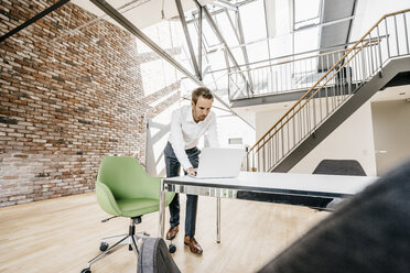 Geschäftsmann mit Laptop im Büro - KNSF00512