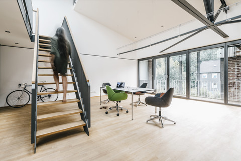 Frau in Bewegung auf der Treppe im Büro, lizenzfreies Stockfoto