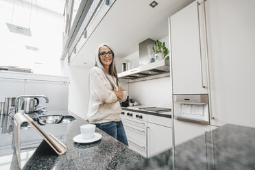 Lächelnde Frau mit langen grauen Haaren in der Küche - KNSF00556