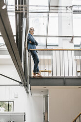 Confident businesswoman with long grey hair in a loft - KNSF00559