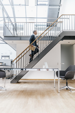 Geschäftsmann auf einer Treppe in einem Loft, lizenzfreies Stockfoto