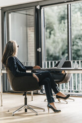 Businesswoman at desk with laptop - KNSF00578