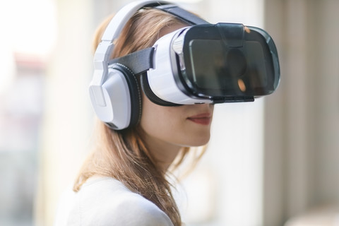 Frau mit Virtual-Reality-Brille und Kopfhörern, lizenzfreies Stockfoto