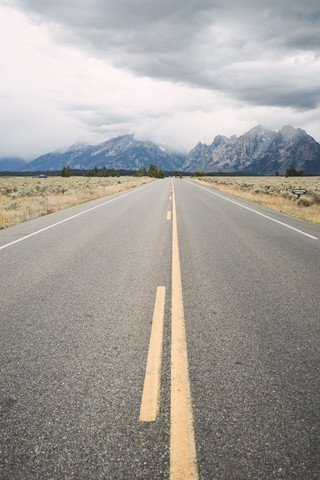 USA, Wyoming, leere Landstraße im Grand Teton National Park, lizenzfreies Stockfoto