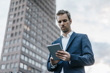 Germany, Berlin, businessman using tablet - KNSF00592