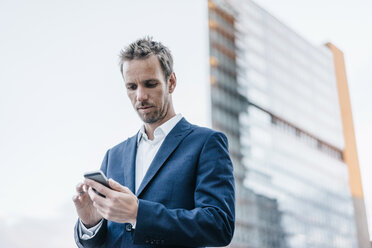 Portrait of businessman using cell phone - KNSF00594