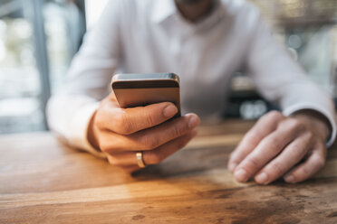 Hand eines Geschäftsmannes, der ein Mobiltelefon hält, Nahaufnahme - KNSF00610