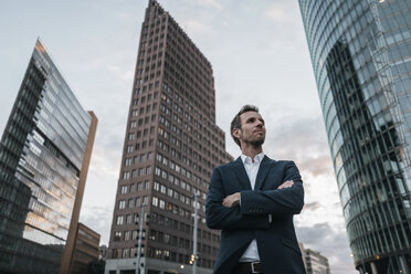 Germany, Berlin, businessman with arms crossed standing at Potsdamer Platz - KNSF00639