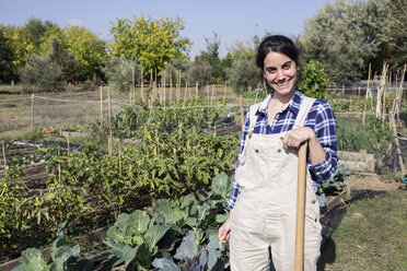 Woman working on farm looking at camera, smiling - ABZF01510