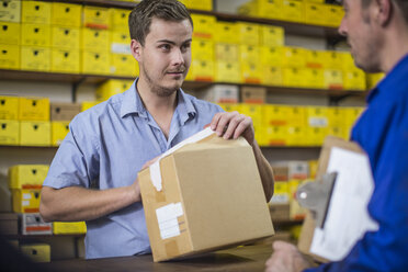 Man in warehouse checking delivered cardboard box - ZEF11612