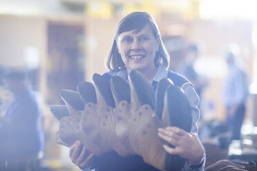 Lächelnde Frau mit Schuhen in der Werkstatt - ZEF11621