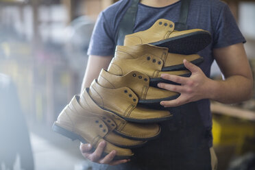 Schuhmacher hält Stapel von Schuhen - ZEF11623