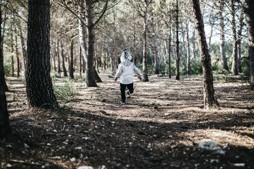 Rückenansicht eines kleinen Jungen mit Kapuzenjacke, der im Wald läuft - JRFF01045