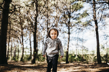 Portrait of little boy wearing hooded jacket in the woods - JRFF01048