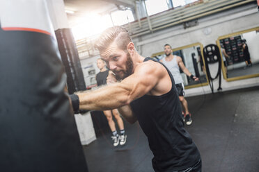 Boxer exercising at punch bag - MADF01234