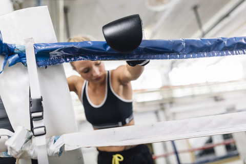 Weiblicher Boxer ruht sich im Boxring aus, lizenzfreies Stockfoto