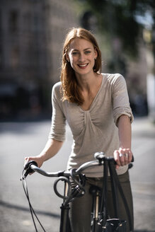Porträt einer rothaarigen Frau mit Fahrrad - TAMF00822