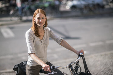 Portrait of redheaded woman with bicycle - TAMF00824