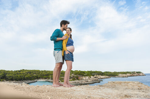Expectant parents standing at the sea - DIGF01451