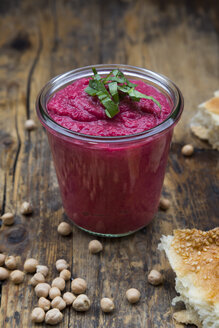 Glas Rote-Bete-Hummus, Kichererbsen und Fladenbrot auf dunklem Holz - LVF05583