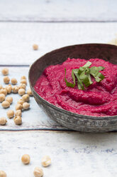 Bowl of beetroot hummus an chick-peas on wood - LVF05586