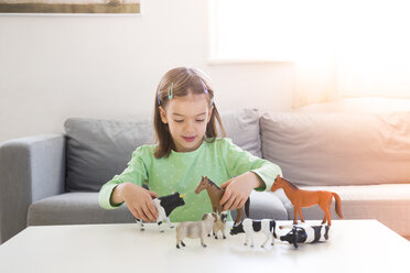 Kleines Mädchen spielt mit Tierfiguren zu Hause - LVF05590