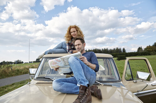 Couple on pick up truck reading map - FMKF03195