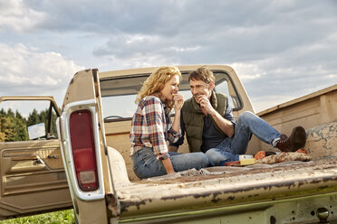 Paar sitzt auf Pick-up-LKW und macht ein Picknick - FMKF03213