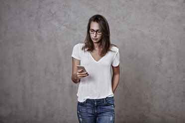 Young woman looking on cell phone - FMKF03243