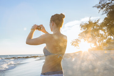 Woman on the beach taking pictures with her smart phone - MMAF00015