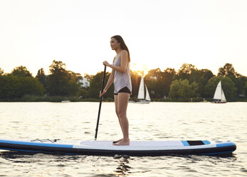 Germany, Hamburg, Young woman on paddleboard enjoying summer - WHF00042