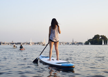 Germany, Hamburg, Young woman on paddleboard enjoying summer - WHF00043