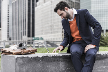 USA, New York City, Businessman working outdoor sitting on bench - UUF09229